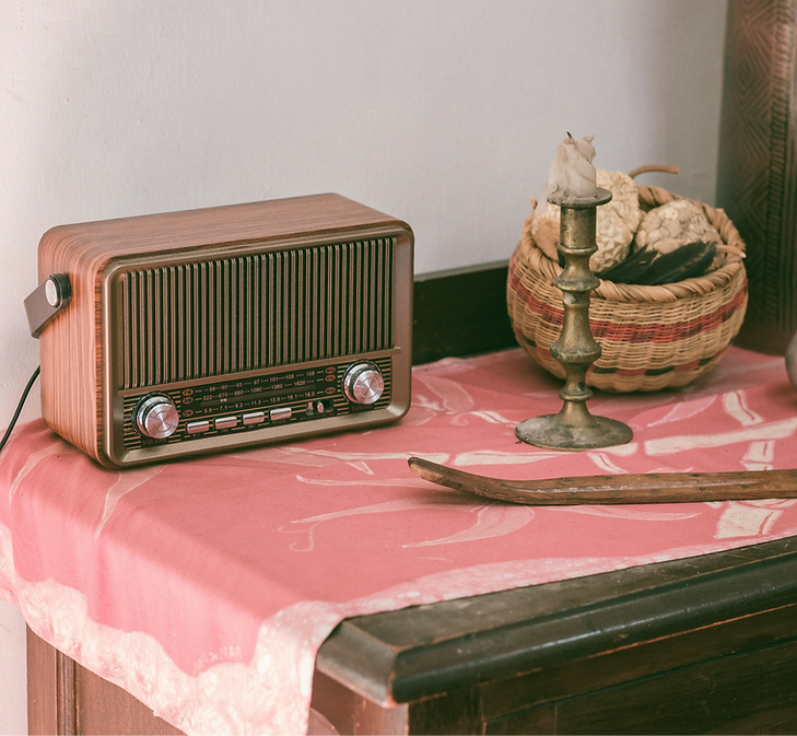 A table topped with a radio next to a vase_edited.png