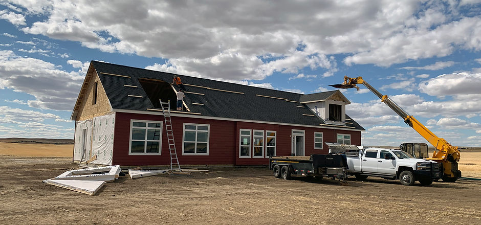 People working on a roof with a crane
