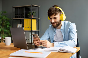 young-man-listening-music-headphones-while-working.jpg