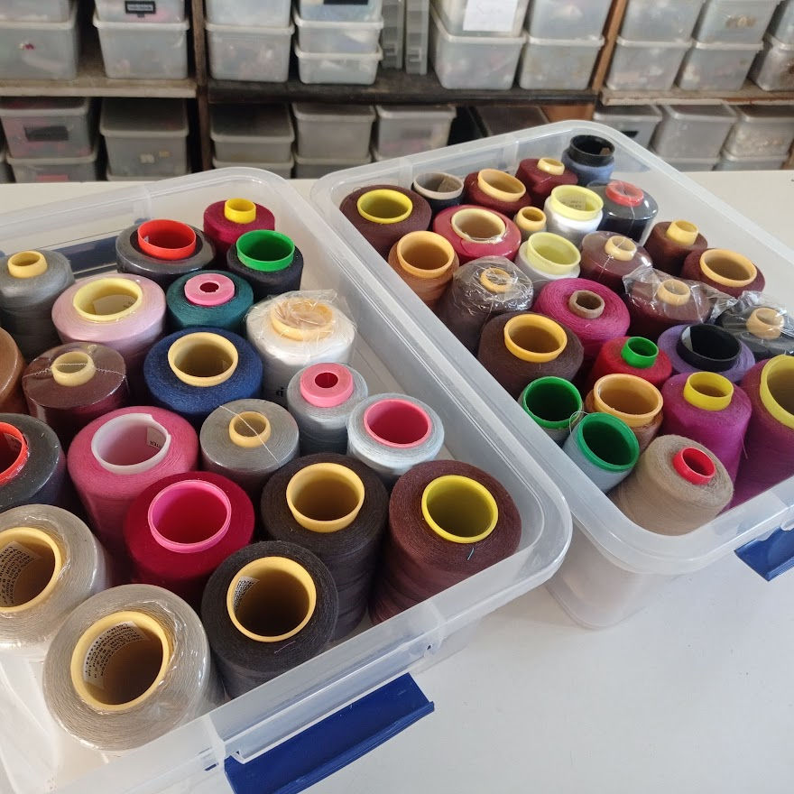 boxes of cones of sewing threads in different colors