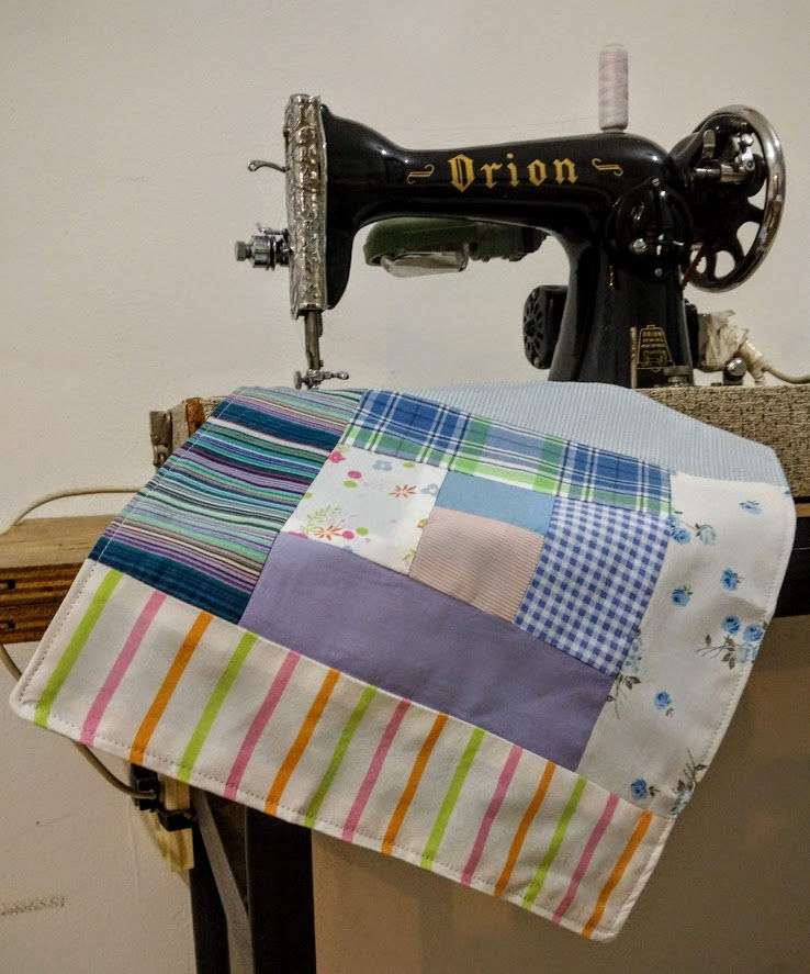 Thumbnail: log cabin fabric square on a black vintage sewing machine