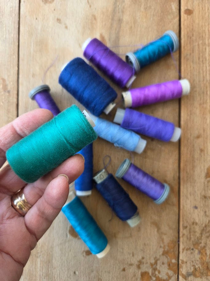 spools of twilight colored sewing threads