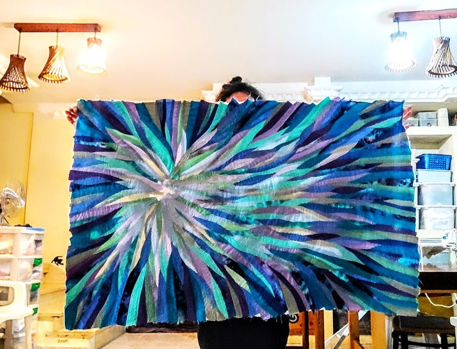 large wave nova star quilt being held aloft