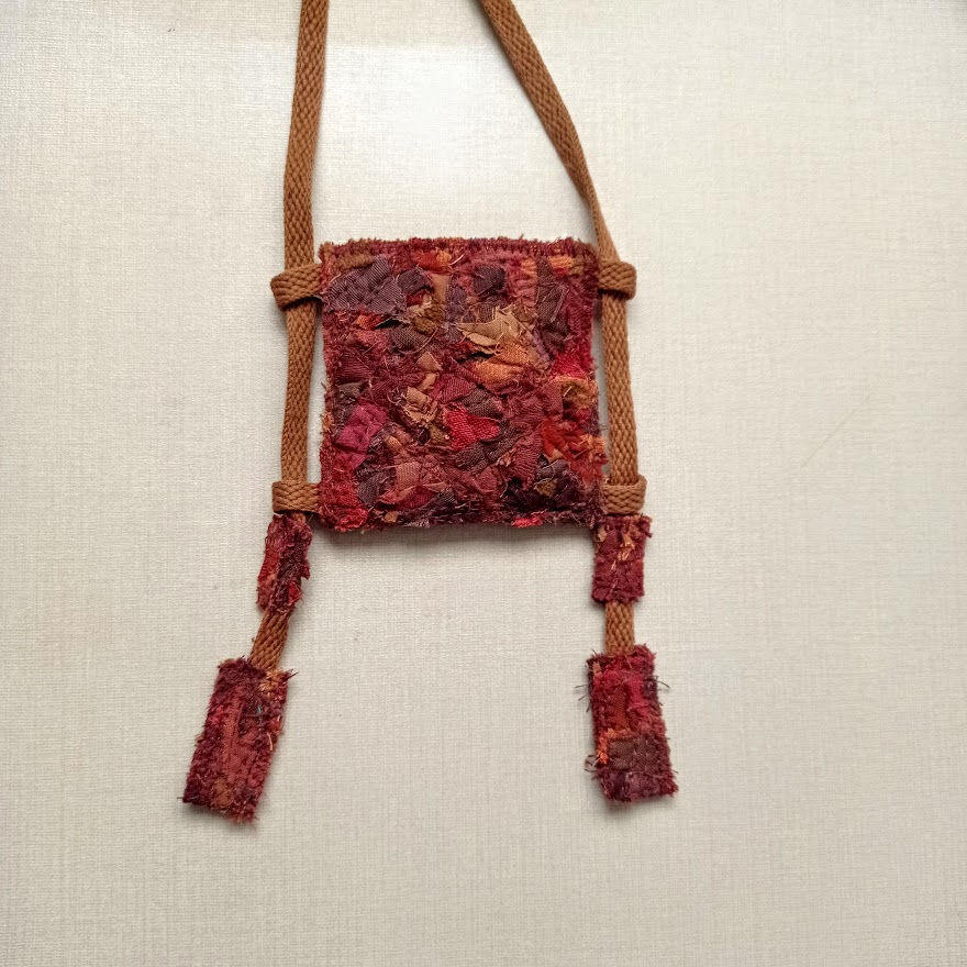 Thumbnail: brown and red pocket amulet