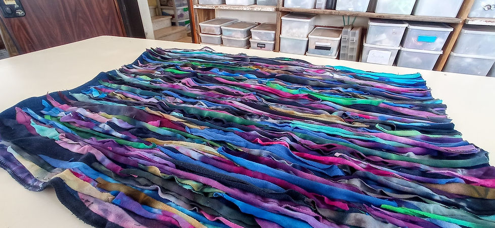 Thumbnail: jewel colored t shirt strip art piece lying on a table