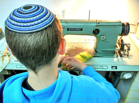 Boy sewing on industrial machine