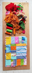 חומרי תפירה צבעוניים: חוטים, בד, וסמרטוטים מוכנים לתפירה