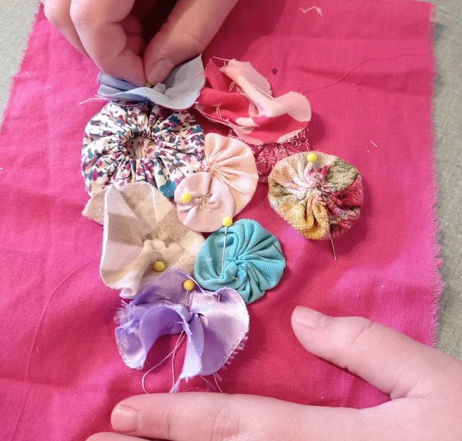 yoyos pinned onto pink fabric