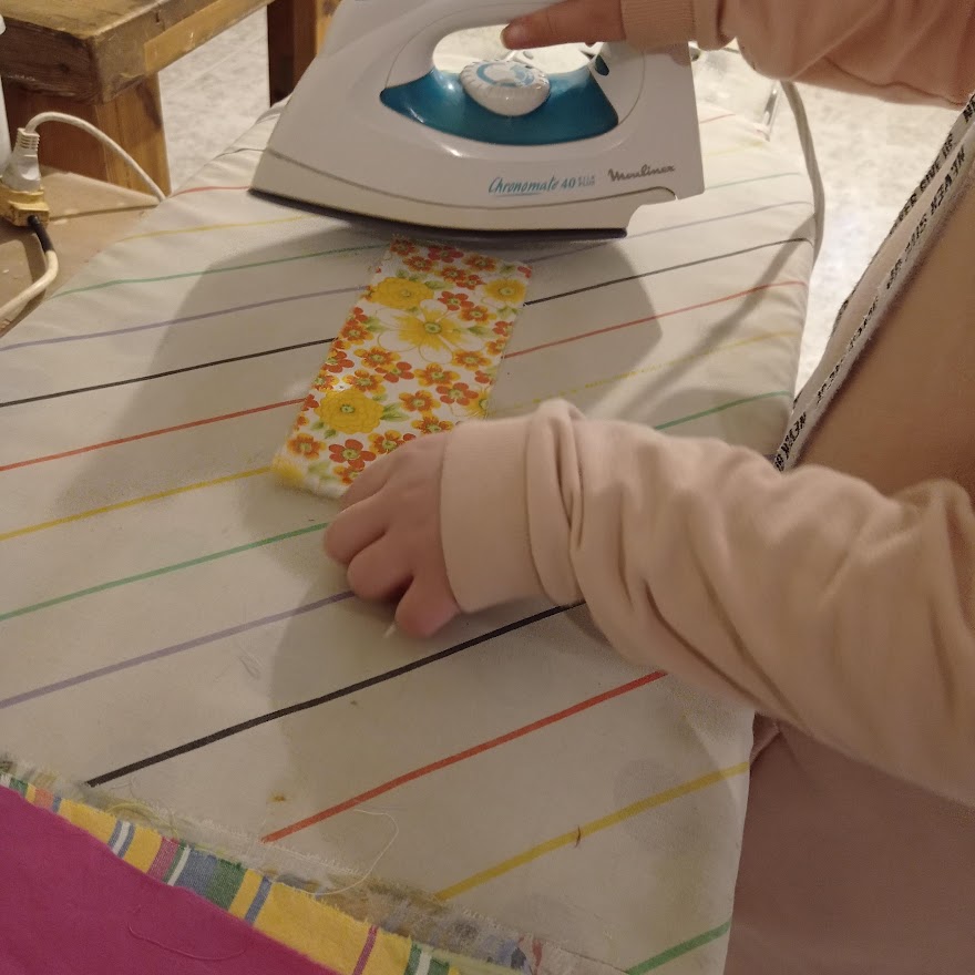 girl ironing fabric strips