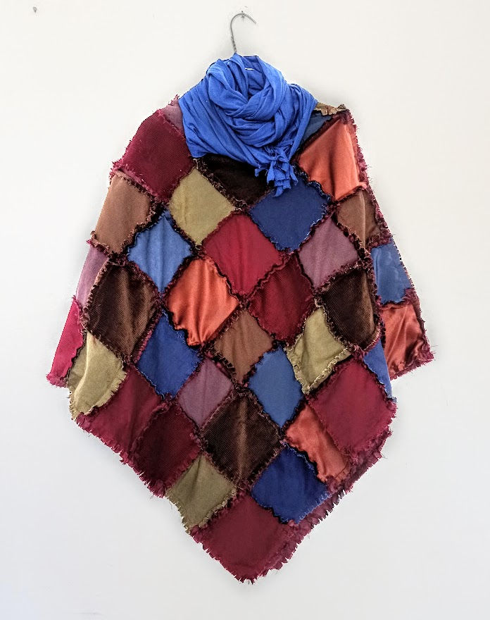 Thumbnail: A rag quilt poncho hanging on the wall