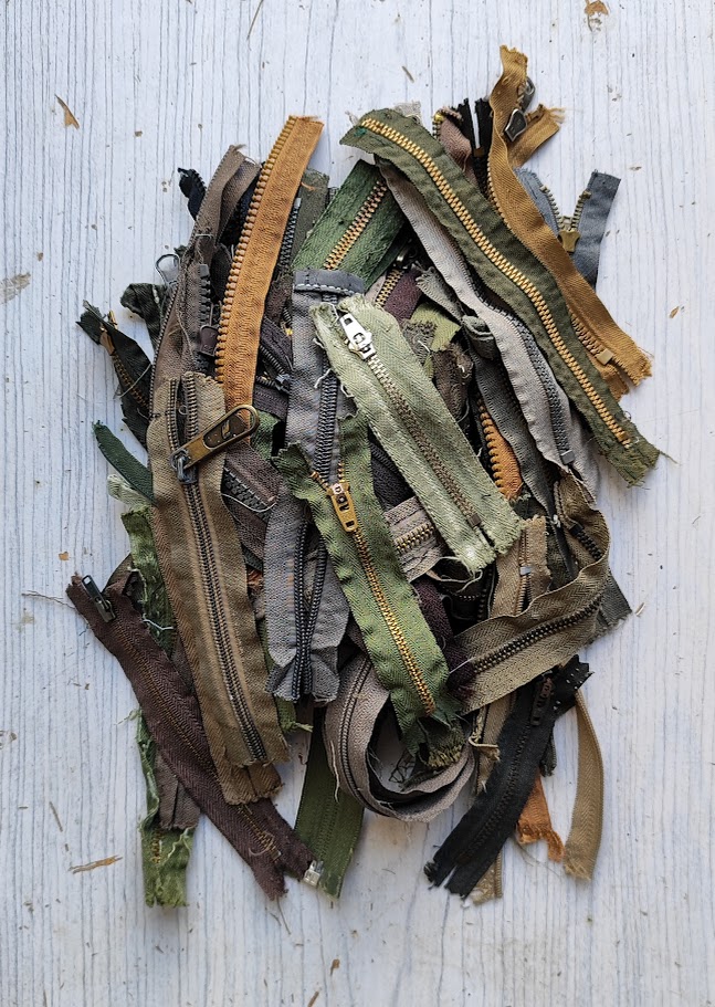a pile of camo colroed zippers on a table