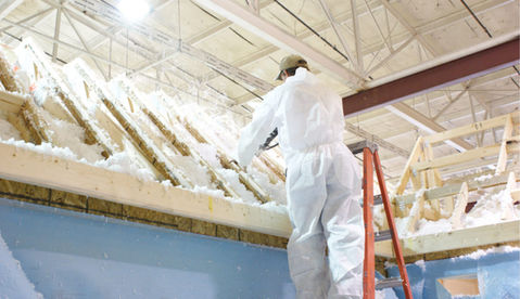 Insulation professional blowing Johns Manville Spyder Fyber insulation into the roof.