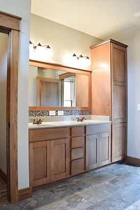 Bathroom has double vanity, maple cabinets with salem maple stain and chocolate glaze, and Onyx in Driftwood with oval bowls.