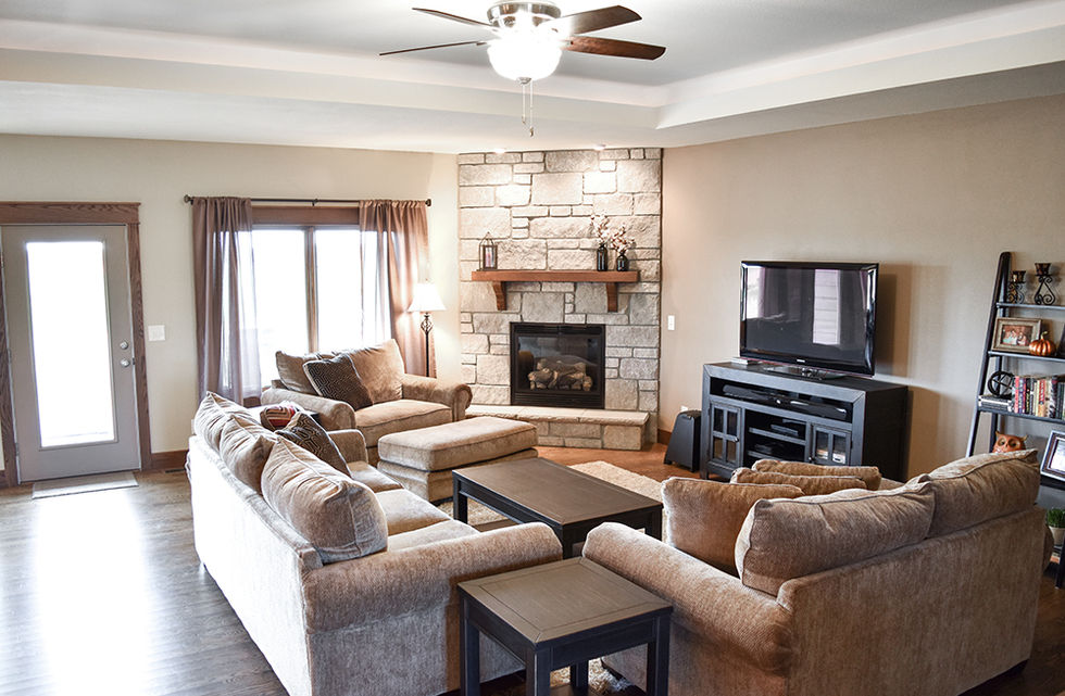 Large living area with stone fireplace and wood mantel above.