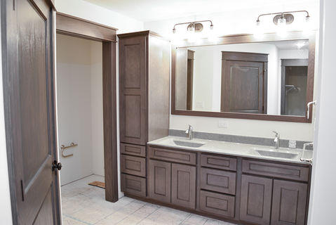 Master bathroom including double-sink vanity with linen cabinets and wood-wrapped mirrors. Wave bowls and Moen Faucets.
