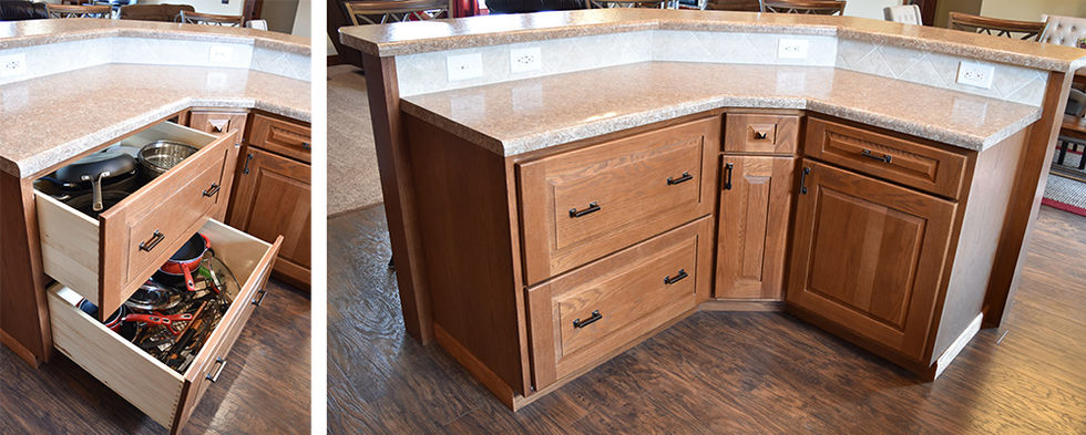 Cabinets and drawers under angled island in kitchen.