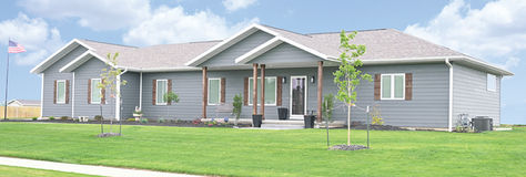 Modular home with gray siding, white trim, and wood accents. Built by Wardcraft in Kansas and Nebraska.