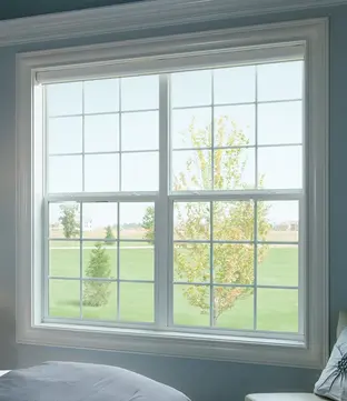 White encompass vinyl single-hung window, 2-wide with grilles, within bedroom.