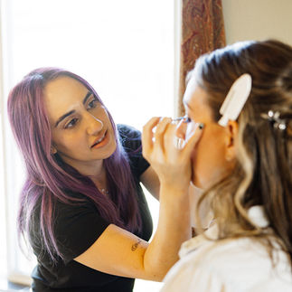 Makeup artist applying mascara to a bride