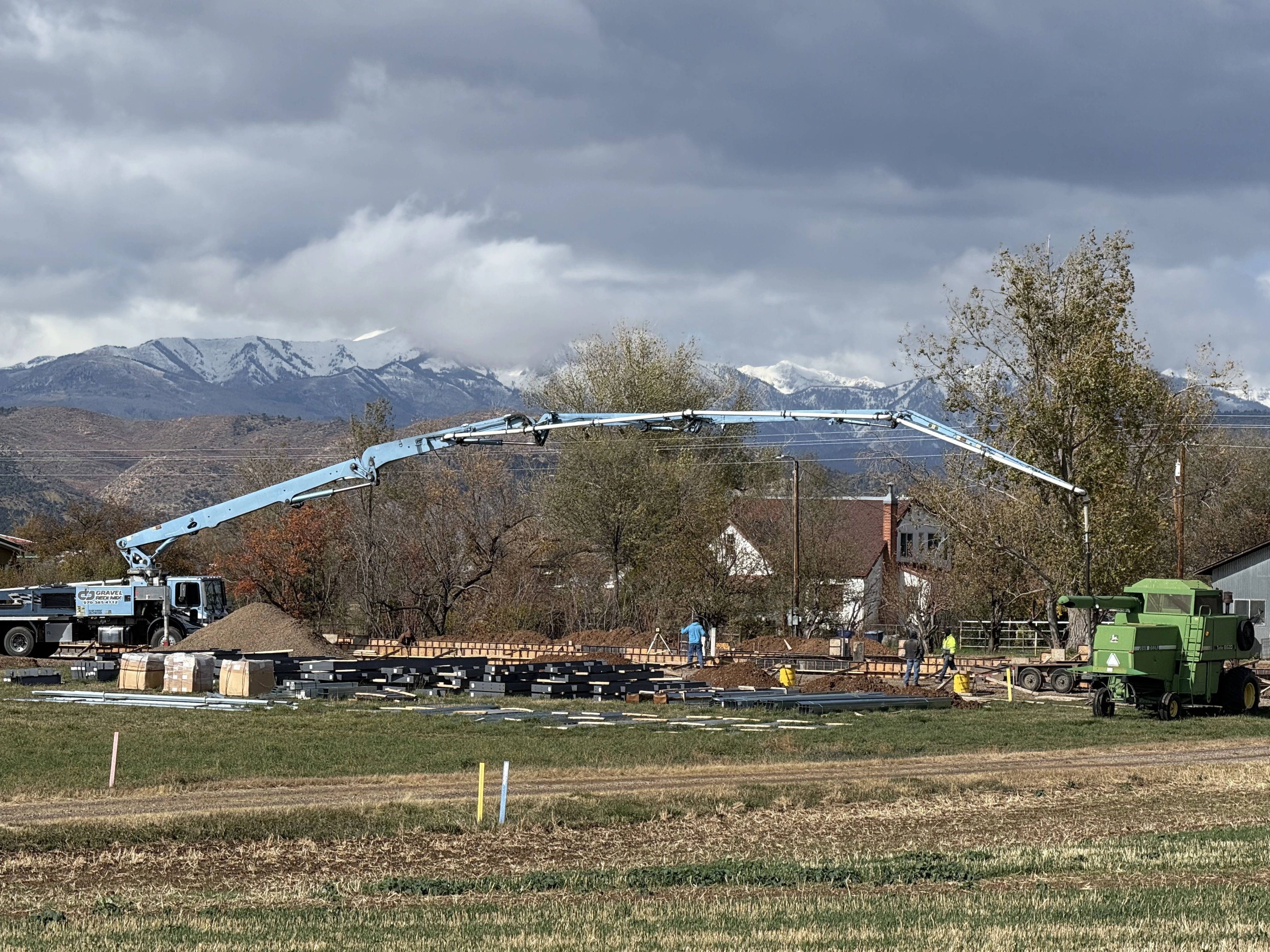 Concrete pump pouring foundation for a ranch building.