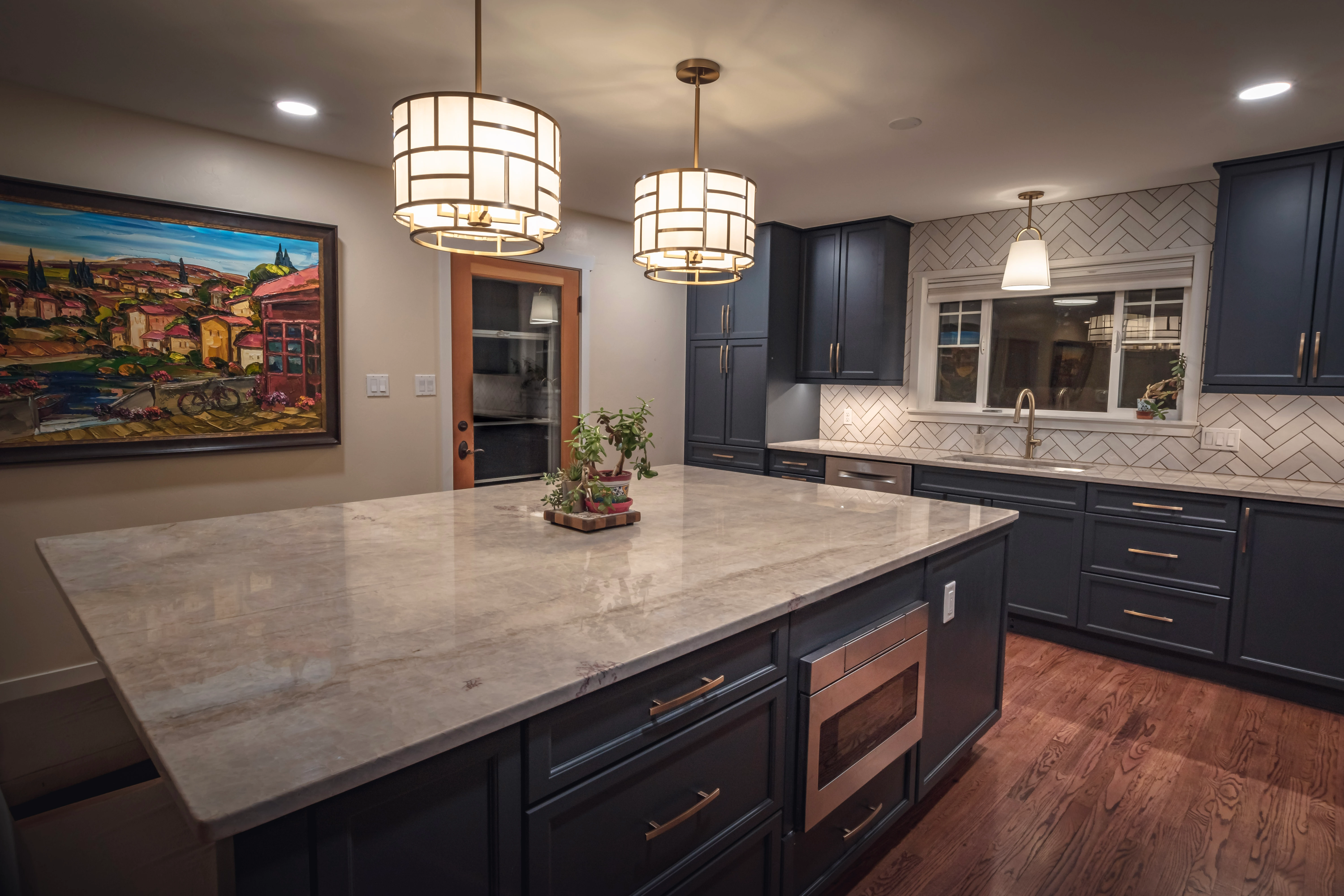 Modern kitchen with dark cabinets, island, and decorative pendant lights