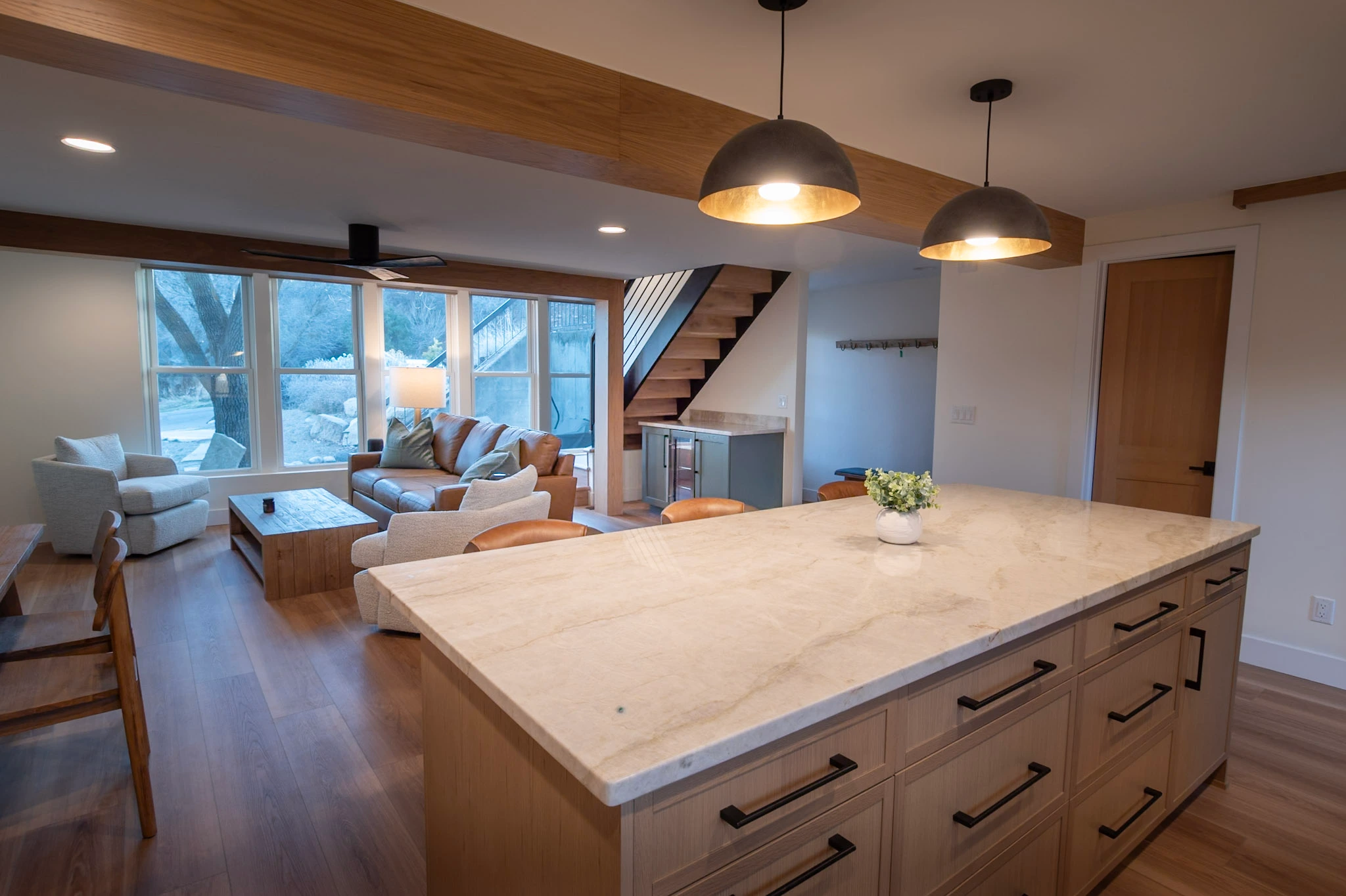 Modern kitchen island and open living room with staircase