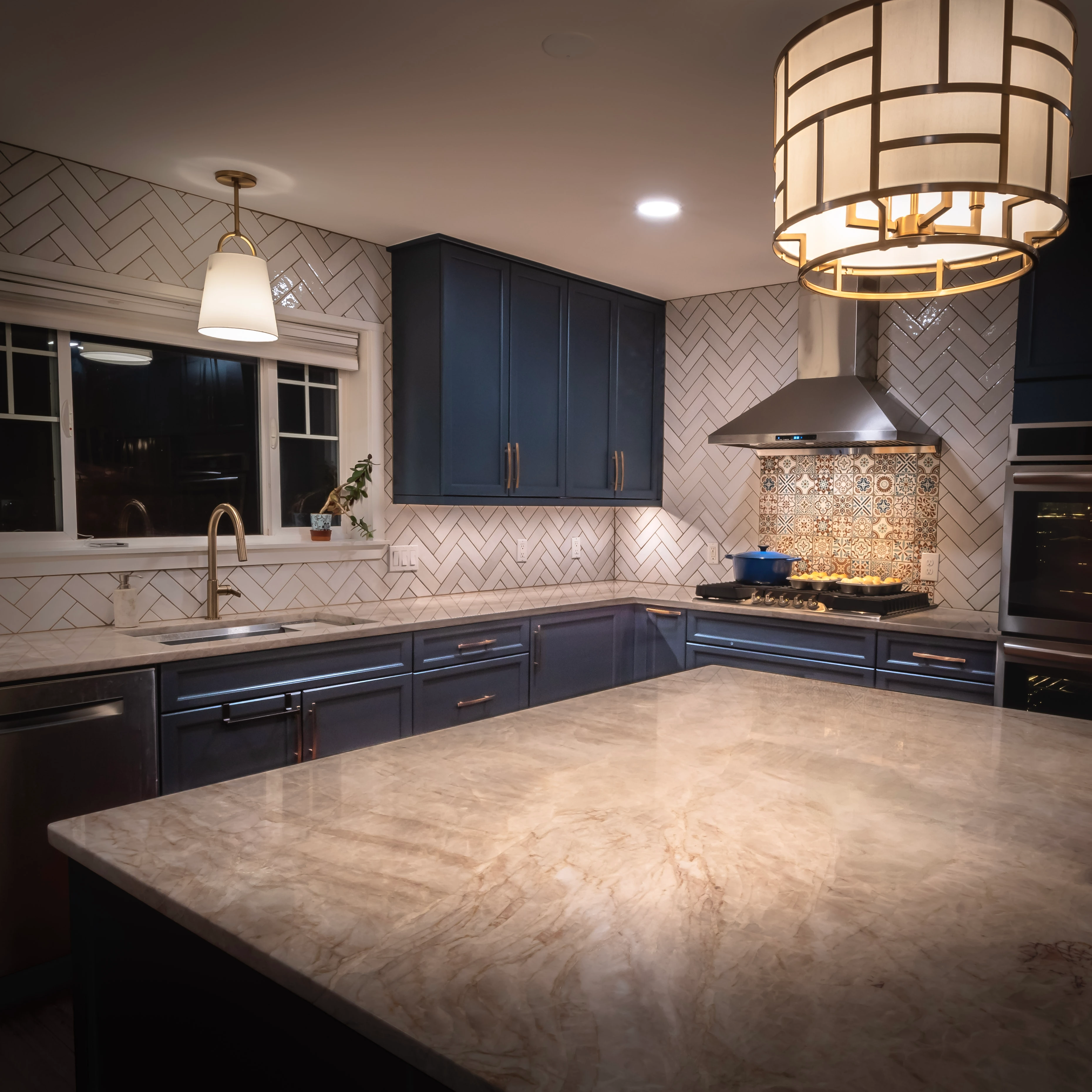 Modern kitchen with blue cabinets, light counters, and island