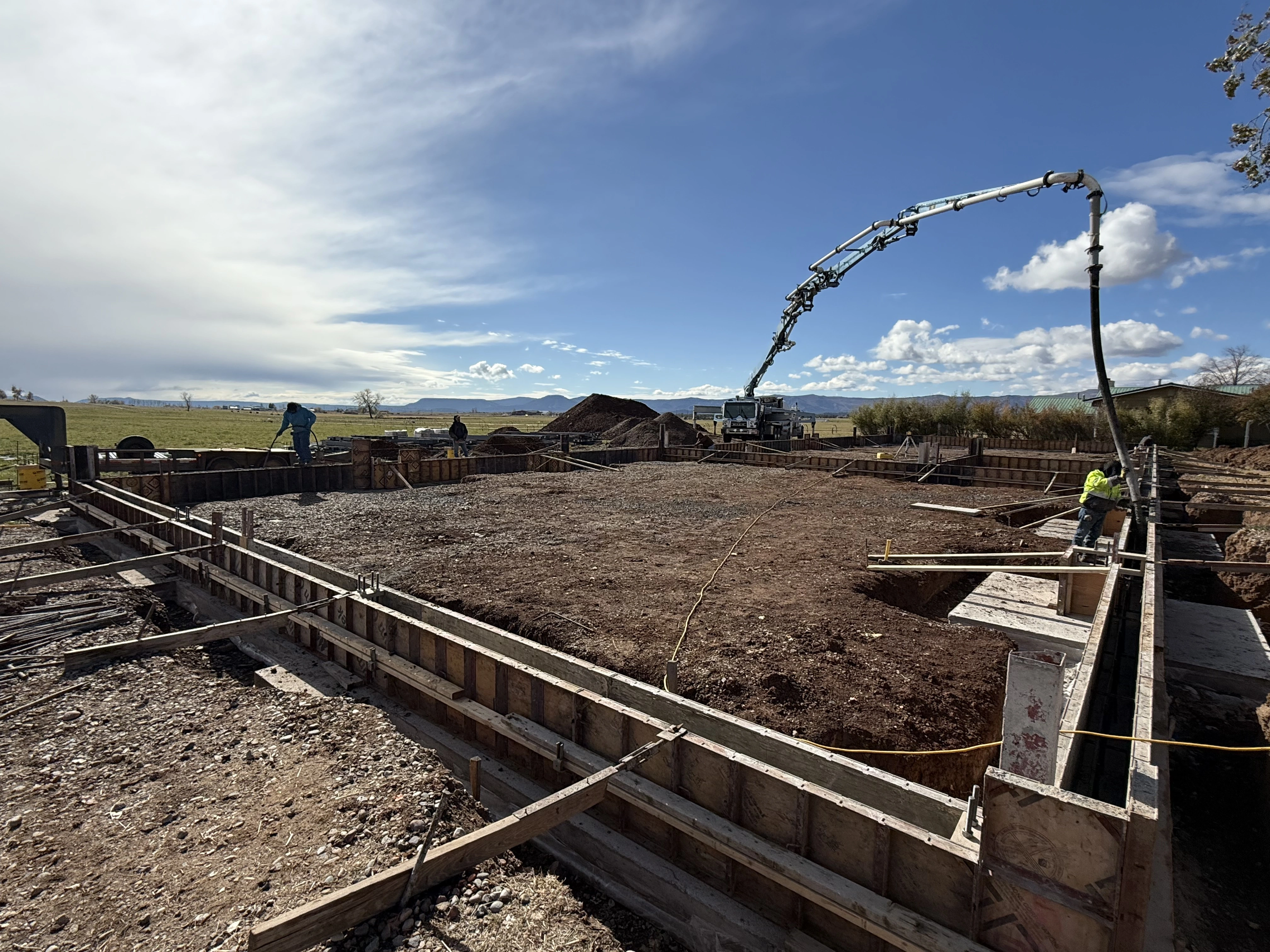 Workers pouring concrete for building foundation
