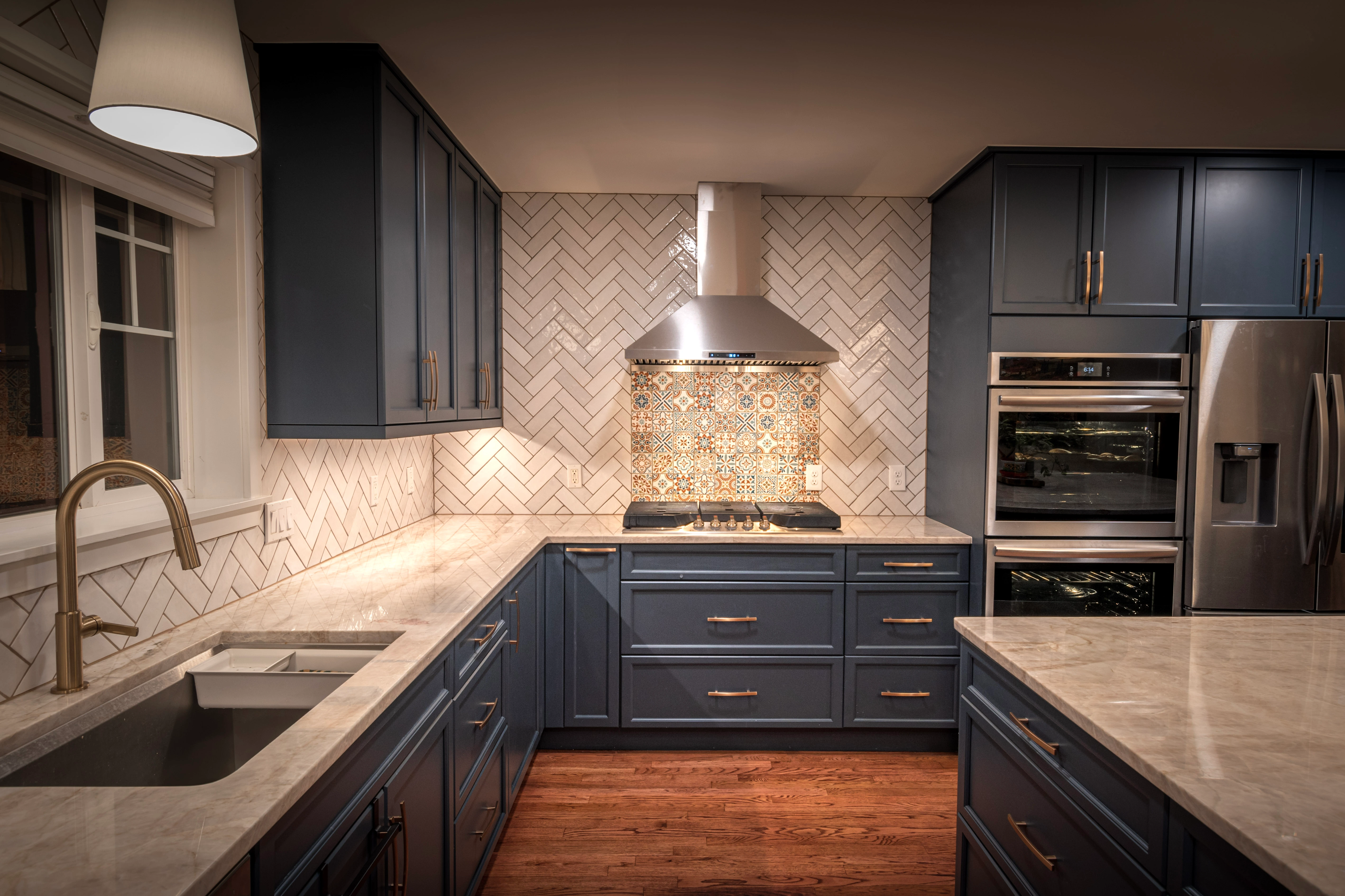 Modern kitchen with blue cabinets and herringbone backsplash