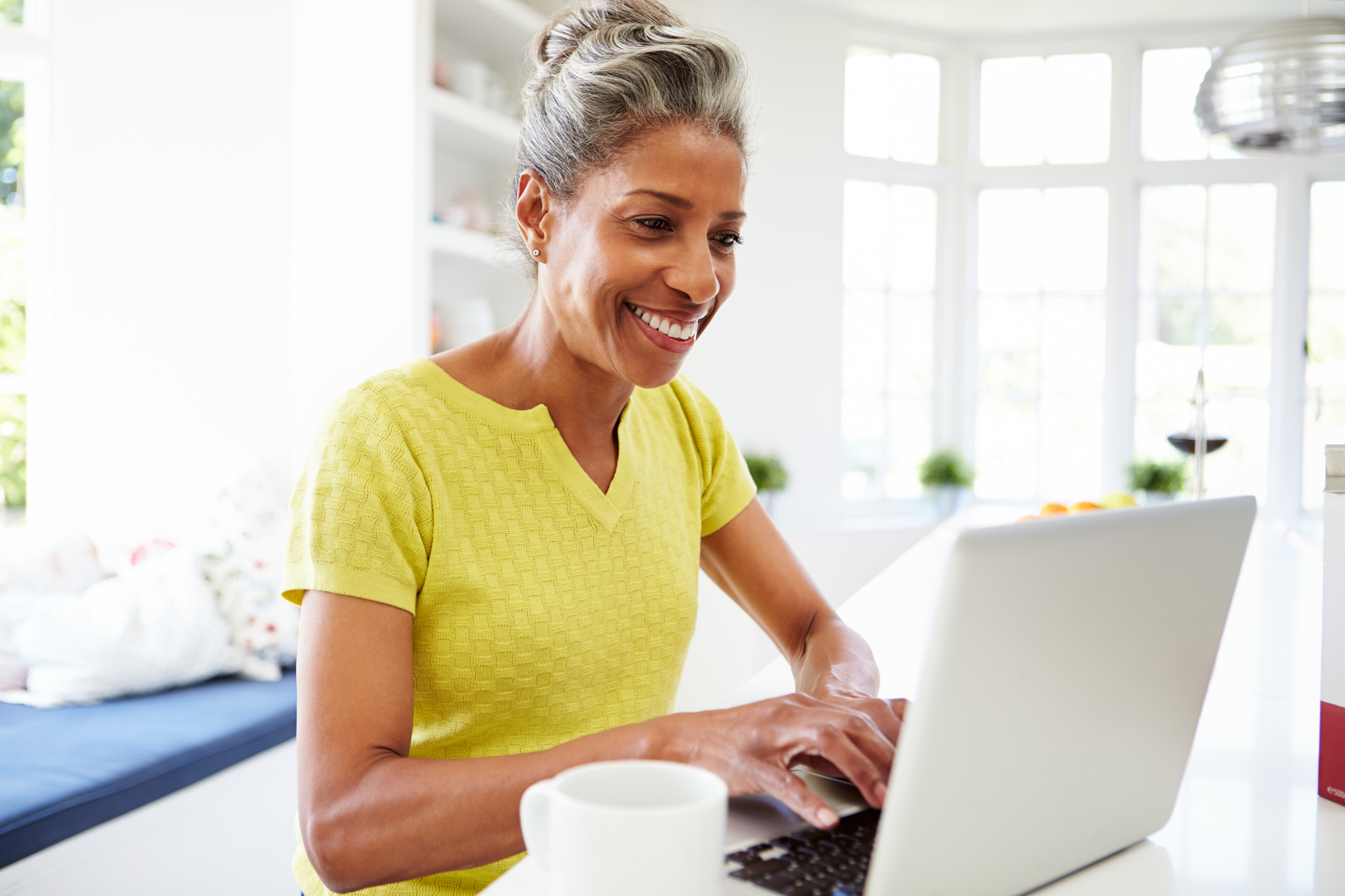 african-american-woman-using-laptop-kitchen-home.jpg