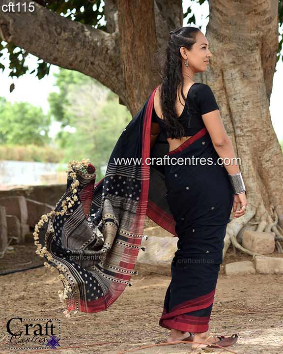 Thumbnail: Woman wearing black saree with www.craftcentres.com, Bhujodi Saree in natural outdoor setting.