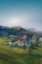 letecký záběr na obec Pavlov s areálem Pavlovských domečků s pozadím zříceniny hradu Děvičky