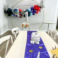 galaxy birthday party with dark colors, stars, and glowing space decorations