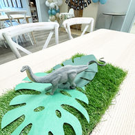 Dinosaur-themed first birthday with green table runner and dino decorations