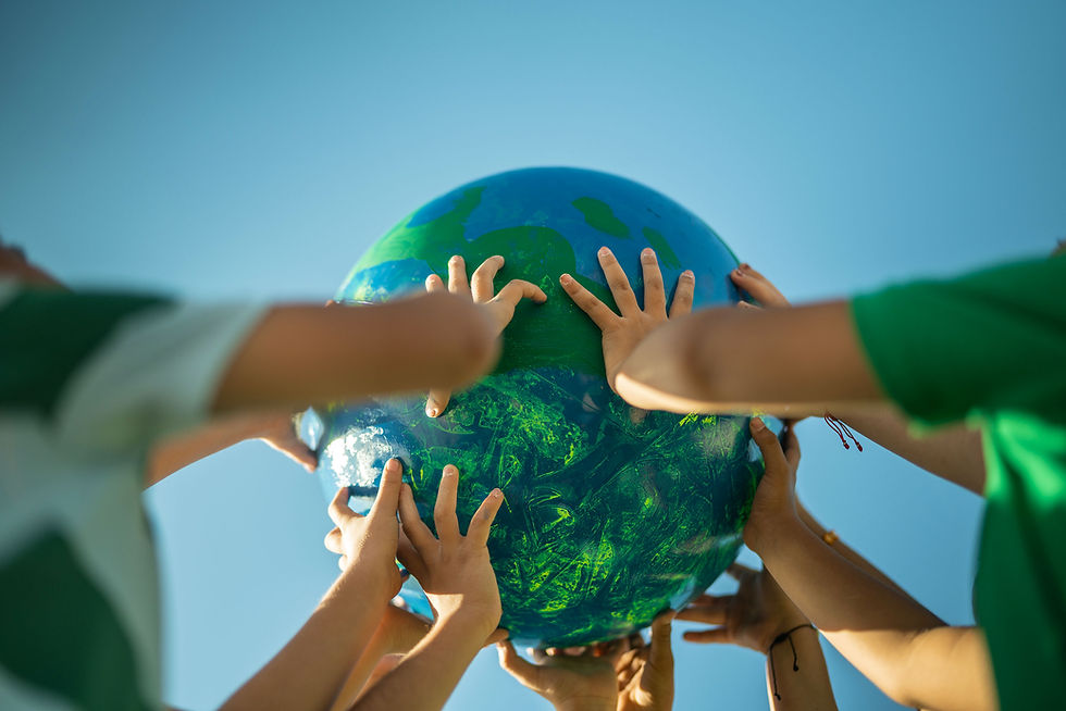 children holding up a globe with sky in the background