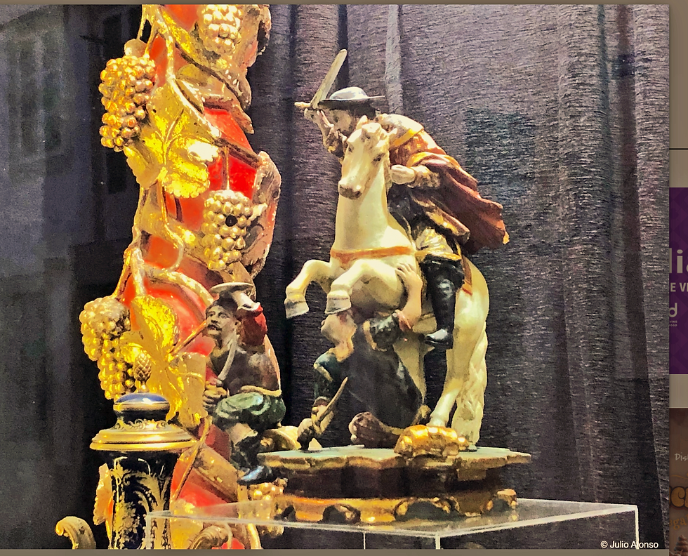 Intricate sculpture of a figure (Santigo Matarmoros, on horseback with sword, surrounded by detailed figures. Vibrant gold and red hues, displayed on a pedestal.