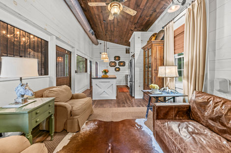 Open guest suite above the barn with vaulted wood ceiling, seating area and bed alcove
