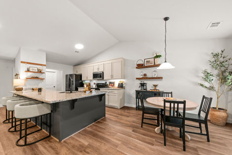 Kitchen island with counter stools and breakfast table beyond