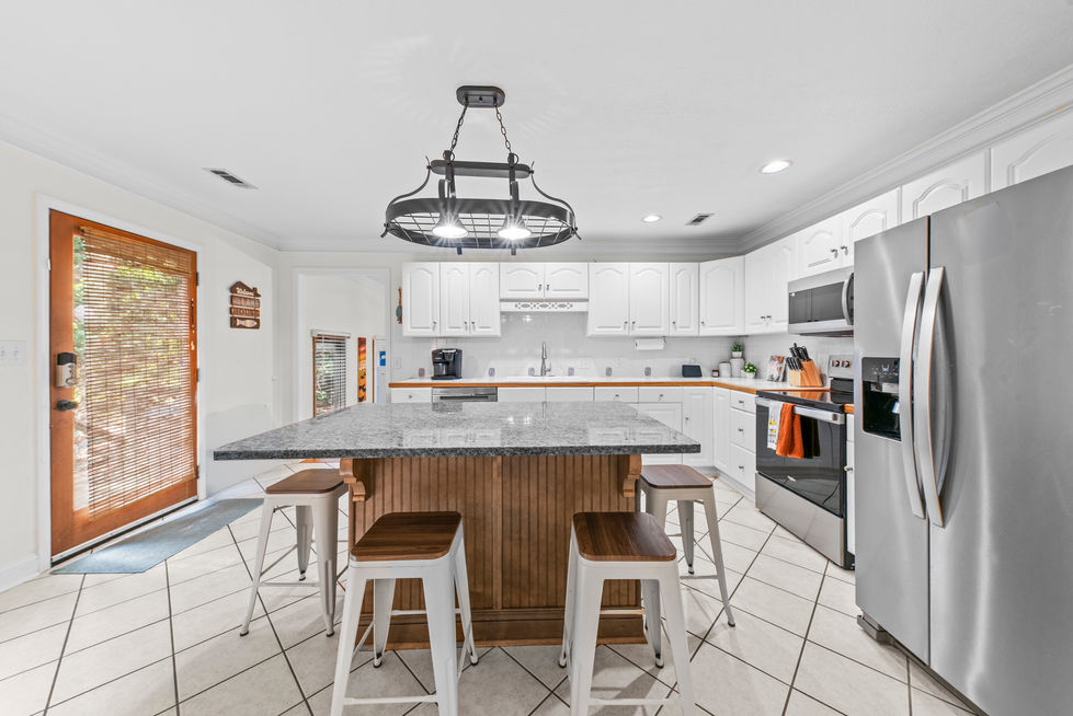 Kitchen with island seating, stainless appliances and iron chandelier