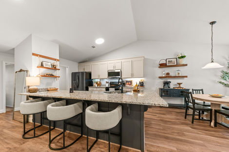 Kitchen island with barstools, open shelving and dining area