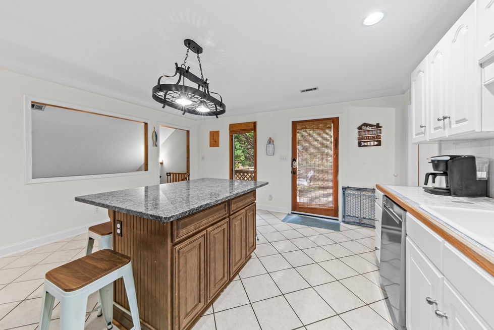 Kitchen island with counter stools and adjacent coffee bar