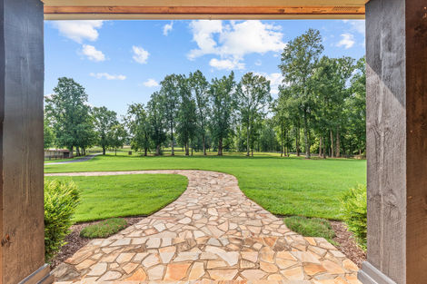 Flagstone walkway leading out to the lawn between porch columns