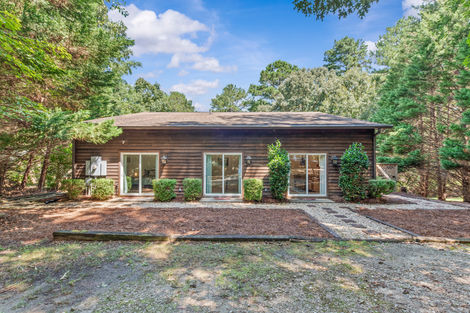 Rear exterior with wood siding and sliding glass doors onto the patio