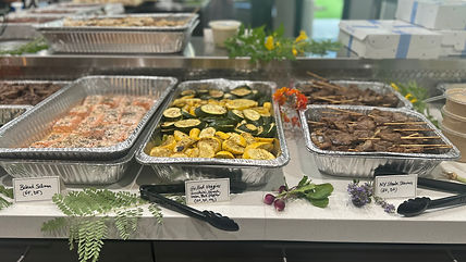 catering trays with salmon, vegetables, and skewers