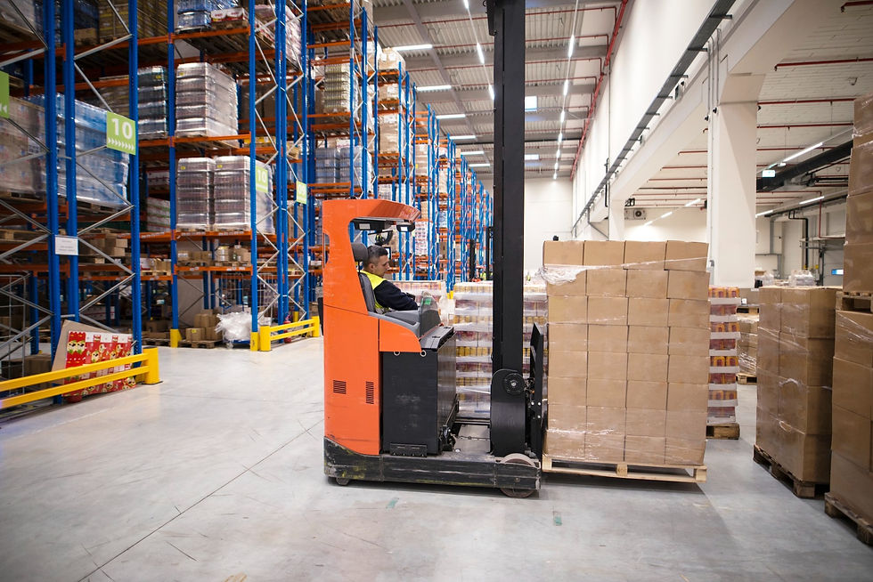 A man on a pallet jack, transporting product throughout a fulfillment warehouse.