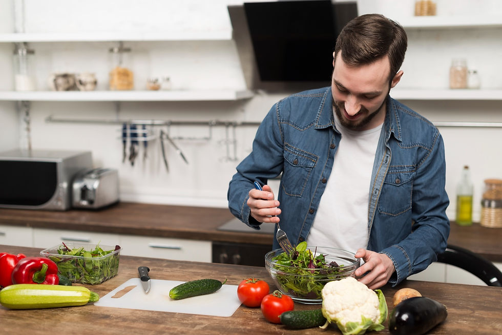 A man putting together a fresh green salad.