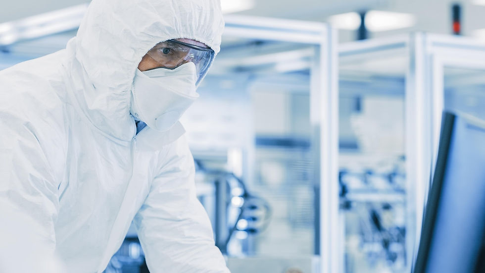 Person in full protective gear and goggles working in a high-tech lab setting. Blue tones dominate, creating a sterile and focused mood.