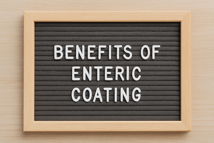 A black letter board with wooden frame displays "BENEFITS OF ENTERIC COATING" in white letters. The background is a light wood surface.