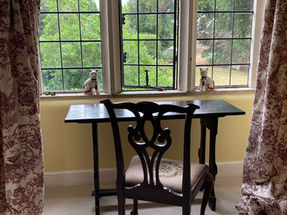 Writing desk and chair overlooking summer garden