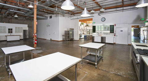 Stage Two at 2010 Studios is a professional standing commercial kitchen stage in Los Angeles, newly remodeled to give productions maximum flexibility. The stage can be configured with two- or three-station layouts, including a fully equipped 3 station cooking standing kitchen set that’s ideal for multi-chef cooking shows, competitions, and branded culinary content. Design options include stainless steel cabinets, clean white cabinets, or open shelving for a variety of looks. Outfitted with (3) 30" Viking stoves, a 27" refrigerator, a 27" freezer, and baker’s racks, this versatile kitchen stage is built to handle large-scale cooking shows, recipe videos, and food commercials. With ground-level access, roll-up doors for easy load-in, and secure on-site parking, Stage Two delivers both functionality and style, making it one of the best commercial kitchen filming studios in Los Angeles.